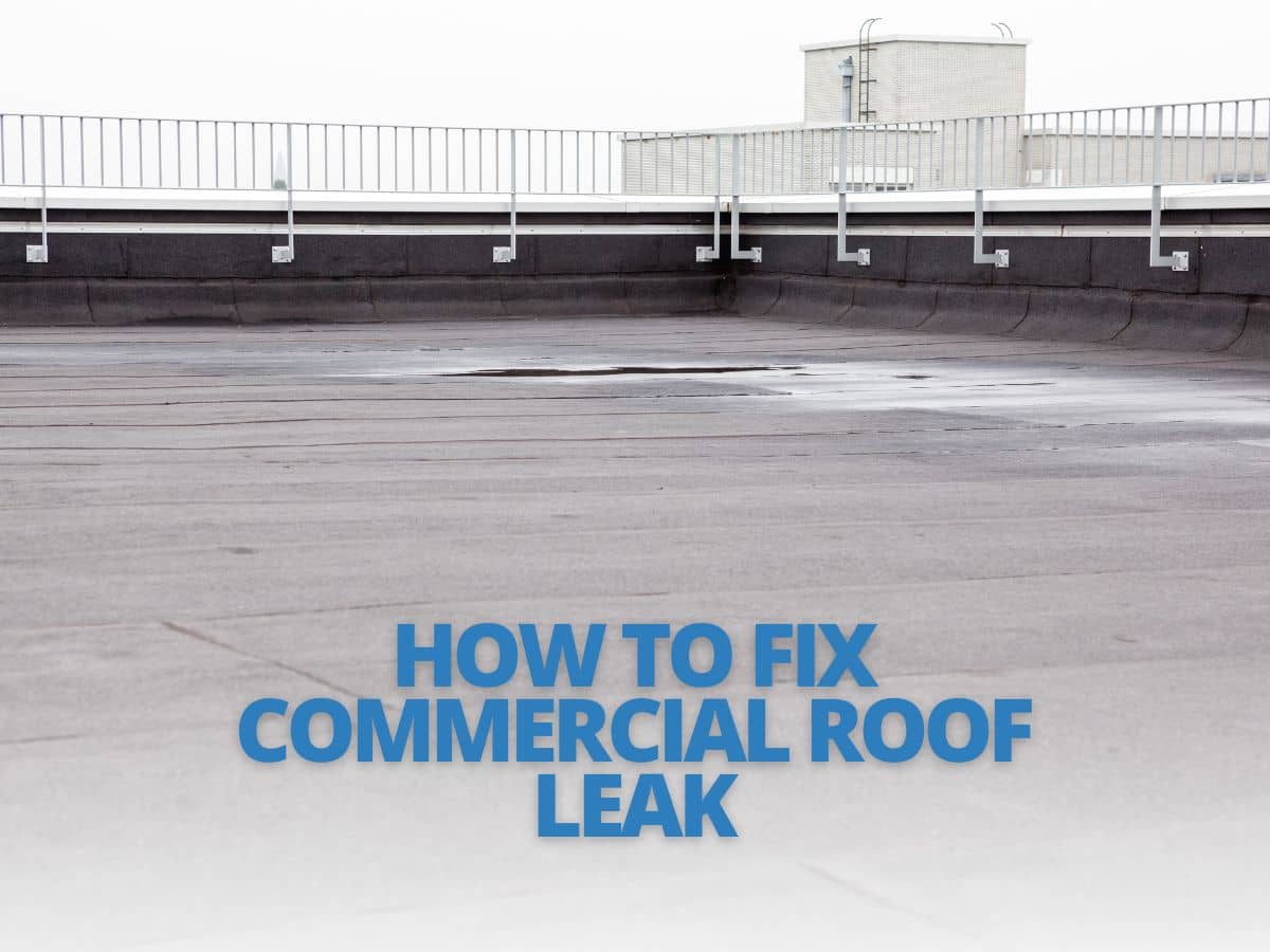 Professional roofer repairing a commercial roof leak, equipped with safety gear and tools.